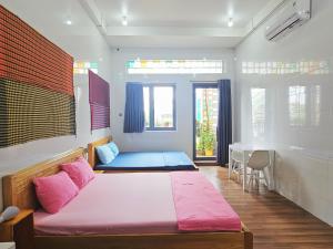 a room with a bed and a table in it at Homestay Khoa Chaudoc in Chau Doc