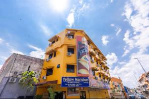 マラッカにあるHotel Q Banda Kaba Near Red Buldingの側面に看板がある黄色い建物