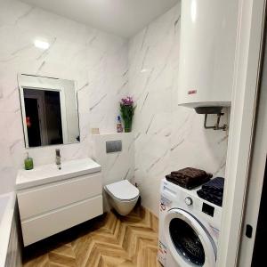 a bathroom with a sink and a washing machine in it at Однокімнатна квартира в ЖК Над бугом in Khmelʼnytsʼkyy