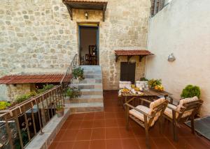 an outdoor patio with a wooden table and chairs at Finestra Medieval Home in Rhodes Town