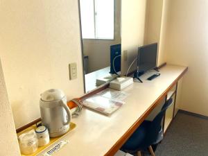 an office desk with a computer and a mirror at Matsue Plaza Hotel Annex in Matsue