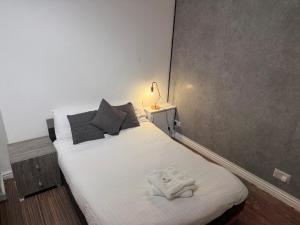 Un dormitorio con una cama con una toalla encima. en Premier Apartmetns Manchester, en Mánchester
