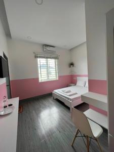 ホーチャムにあるMotel Thuỷ Lộc Hồ Tràmのピンクと白の壁のベッドルーム1室(ベッド1台付)