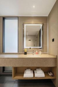 a bathroom with a large sink and a mirror at City Comfort Inn Zhanjiang Middle Haibin Avenue Wanda Plaza in Zhanjiang