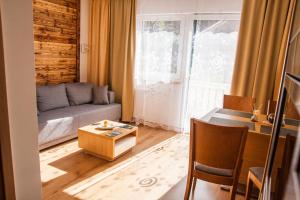 ein Wohnzimmer mit einem Sofa und einem Tisch in der Unterkunft Apartment Michael - Zell am See - Kaprun in Piesendorf