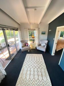 a living room with two chairs and a rug at The Summer House in Mangonui