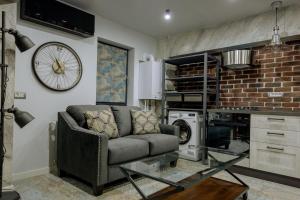 a living room with a couch and a brick wall at Apartament Duo Style in Brăila