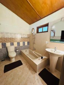 a bathroom with a sink and a tub and a toilet at The Forest Inn Kandy in Kandy +36 photos