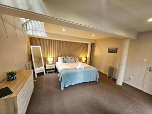 a bedroom with a large bed and a large window at Beautiful Apartment Surrounded by Native Bush in Picton