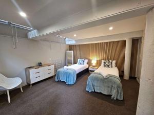 a bedroom with two beds and a dresser in it at Beautiful Apartment Surrounded by Native Bush in Picton +19 photos