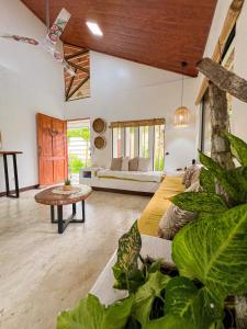 a living room with a couch and a table at Casa Amor Un bello Hospedaje Cerca del Océano in Puerto Jiménez
