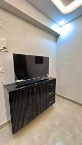 a room with a flat screen tv on a wall at NIRA Luxe stay in Lucknow +5 photos