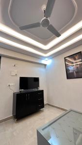 a living room with a ceiling fan and a flat screen tv at NIRA Luxe stay in Lucknow