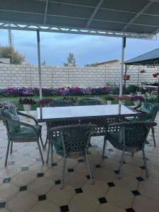 a table and chairs sitting under an umbrella at Guest House "MIDNIGHT" in Talas +7 photos
