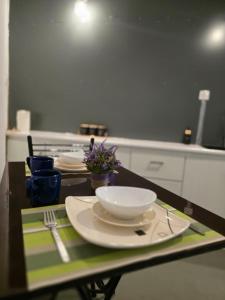 a table with plates and utensils in a kitchen at The Cottage Kandy in Kandy +24 photos