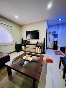 a living room with a coffee table and a flat screen tv at Moderno departamento en el corazón de la ciudad in Trinidad +9 photos