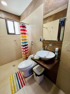 a bathroom with a white toilet and a sink at Moderno departamento en el corazón de la ciudad in Trinidad