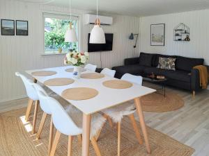 a living room with a white table and white chairs at Family Holiday Home Close To Beach At Vejlby Fed in Vejlbyskov