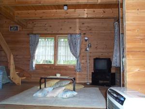 Pokój z łóżkiem i telewizorem w kabinie w obiekcie Cottage Mogi Log House w mieście Nasu