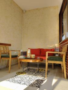 a living room with a red couch and a table at Hotel Casa Centenario Getsemaní in Cartagena de Indias