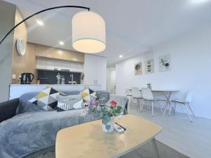 a living room with a couch and a table at Cozy 2B apartment in Belconnen GYM POOL in Belconnen