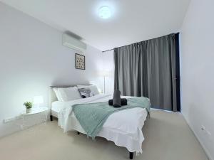 a white bedroom with a bed and a window at Cozy 2B apartment in Belconnen GYM POOL in Belconnen +13 photos