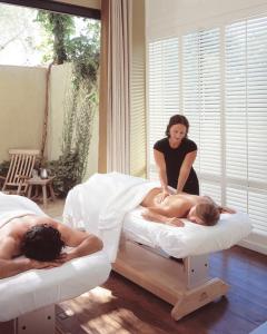 two people laying on beds in a room with a therapist at Hotel Healdsburg in Healdsburg