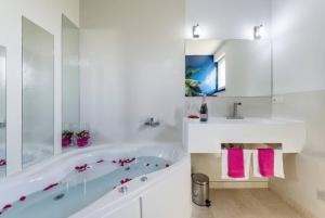 ein weißes Badezimmer mit Badewanne und Waschbecken in der Unterkunft Luxury Apartment with Private Heated Pool in Šibenik