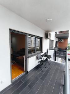 a room with a balcony with a table and chairs at EastWest Nest Sarajevo in Vogošća