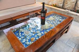 einen Glastisch mit einer Flasche und einem Weinglas in der Unterkunft Apartments Domalu in Zadar