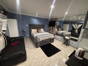 Un dormitorio con una cama, un sofá y un espejo. en Brown Accomodation, en Cape Town
