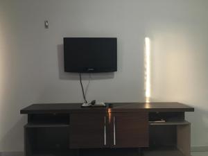 TV de pantalla plana en la parte superior de un escritorio en Apartamento Praia De Manaíra, en João Pessoa