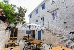 an outdoor patio with tables and chairs and a staircase at Bifora Heritage Hotel in Trogir