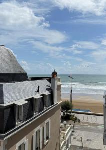 uitzicht op het strand vanaf het balkon van een gebouw bij La Plage Studio lumineux, balcon vue mer in Les Sables-dʼOlonne