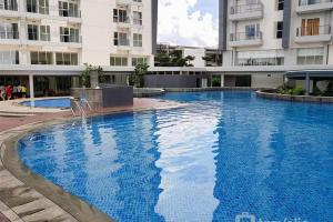 une grande piscine bleue devant un immeuble dans l'établissement Cozy Studio near ICE BSD & AEON Mall, à Samporo