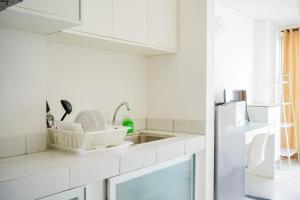 La cuisine blanche est équipée d'un évier et d'un réfrigérateur. dans l'établissement Cozy Studio near ICE BSD & AEON Mall, à Samporo