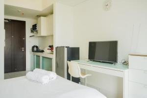une chambre avec un lit et un bureau avec une télévision dans l'établissement Cozy Studio near ICE BSD & AEON Mall, à Samporo