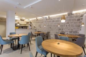 a restaurant with wooden tables and blue chairs at Bifora Heritage Hotel in Trogir