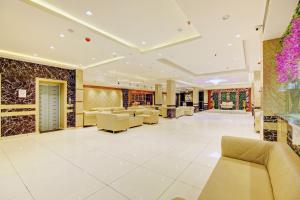 a lobby of a hotel with couches and tables at Hotel O Kinsfolk Inn in Ghaziabad
