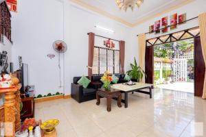 a living room with a couch and a table at Villa Khu Á Châu Hồ Bơi có Sân bbq in Vung Tau