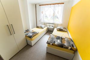 Dos camas en una habitación pequeña con ventana. en Klimczoka 6, en Katowice