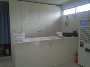 Pokój z białymi szafkami i blatem z papierami w obiekcie Simple Stay Miyajima w mieście Hatsukaichi