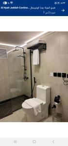 a bathroom with a toilet and a glass shower at بيتوتات التيسير in Jeddah