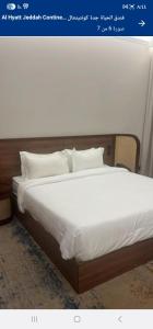 a bed with white sheets and pillows on it at بيتوتات التيسير in Jeddah