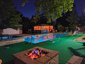 a swimming pool with a fire pit in a backyard at night at Luxury Glamping in the Mile High - Private pool, Hot Tub, and Outdoor Fire Pit!! in Westminster