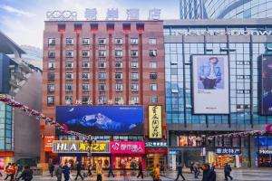 a building with a large sign on it in a city at Xana Hotelle Chongqing Jiefangbei Center Branch in Chongqing