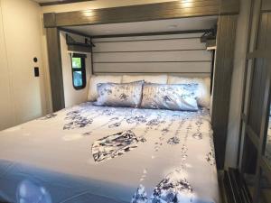 a bed with blue and white sheets and pillows at Luxury Glamping in the Mile High - Private pool, Hot Tub, and Outdoor Fire Pit!! in Westminster +32 photos
