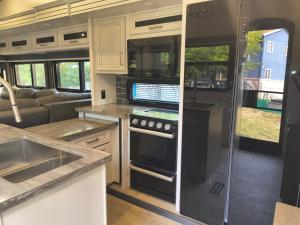 an rv kitchen with a sink and a stove at Luxury Glamping in the Mile High - Private pool, Hot Tub, and Outdoor Fire Pit!! in Westminster