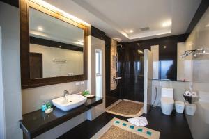 a bathroom with a sink and a shower and a toilet at Hotel and Beach Bungalow at Lanta Resort in Ko Lanta