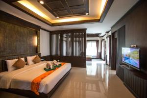 a bedroom with a large bed and a tv at Hotel and Beach Bungalow at Lanta Resort in Ko Lanta +148 photos